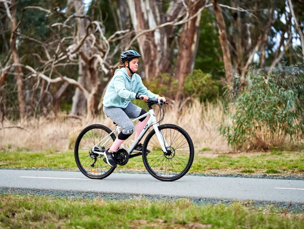 Young girl riding bike on a bike path